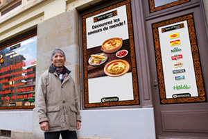 Man in front of his shop with Taste of Home advertising 