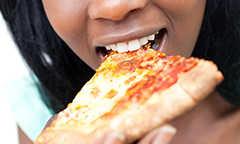 woman eating a slice of pizza