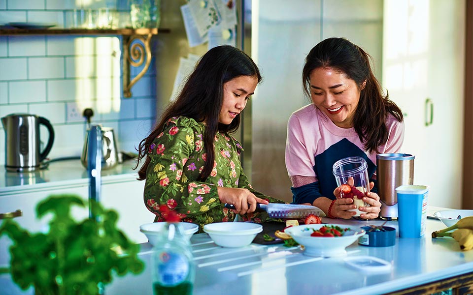 Mother daughter making smoothie