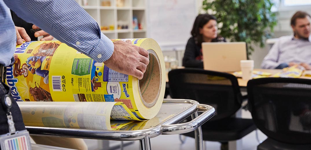 Man rolling recyclable Nesquik packaging