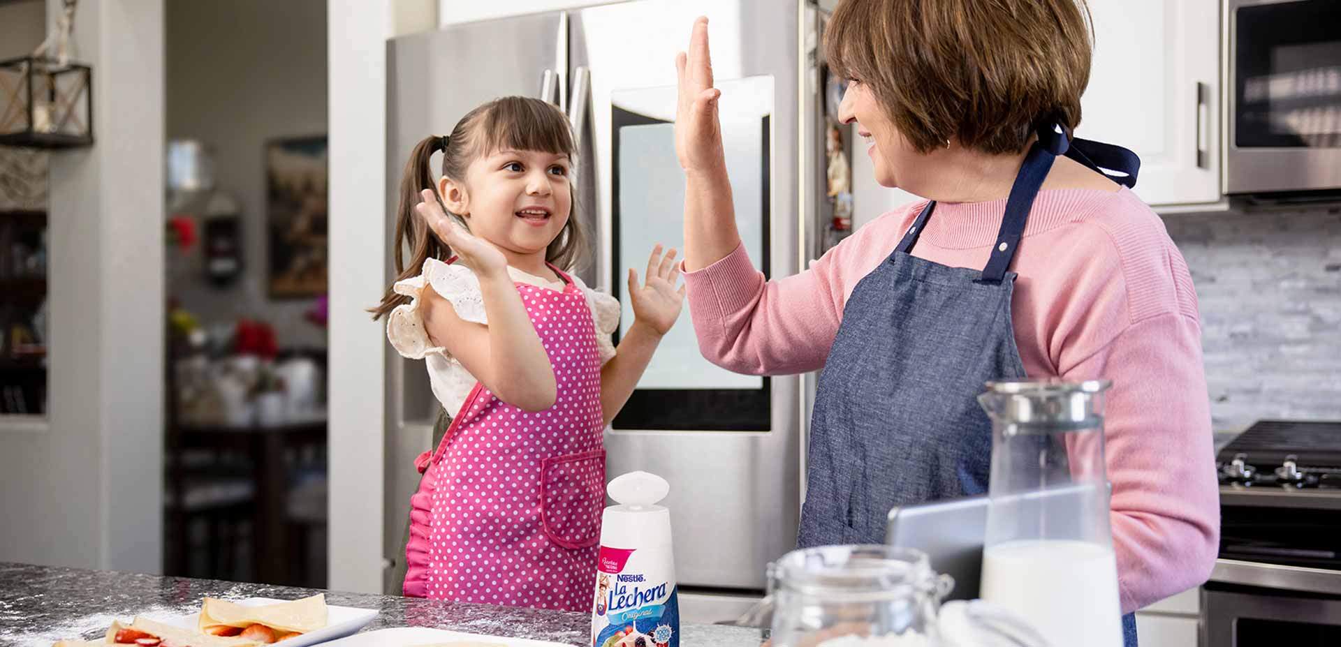 Grandma and granddaughter cooking with La Lechera