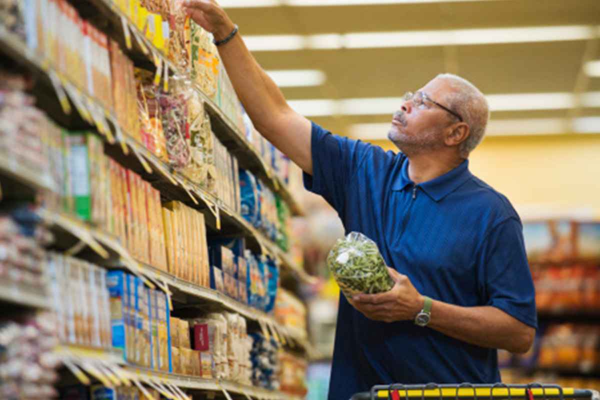 Man reading food label in grocery store