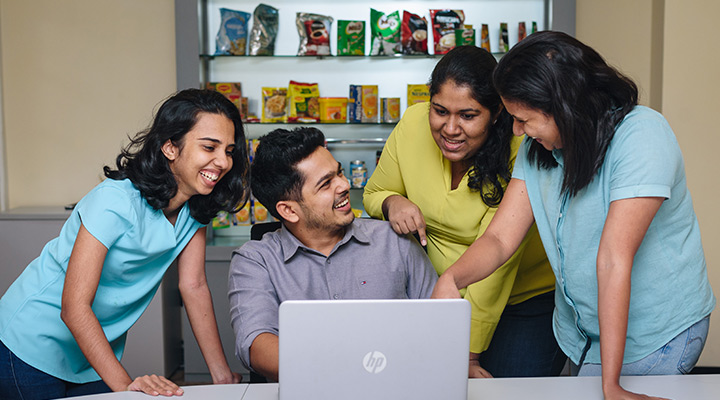 People gathered around a laptop