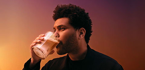 Person drinking a cold beverage from a clear cup