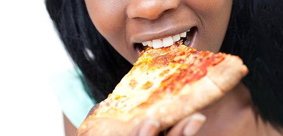 woman eating a slice of pizza