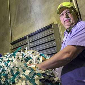 Factory worker preparing waste for recycling Factory worker preparing waste for recycling