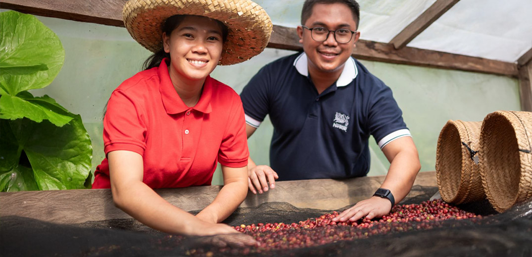 Coffee farmer standing among coffee plants in a sustainable coffee plantation