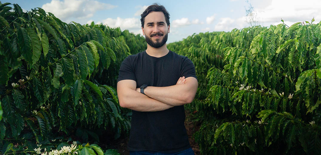 offee farmer standing among coffee plants in a sustainable coffee plantation