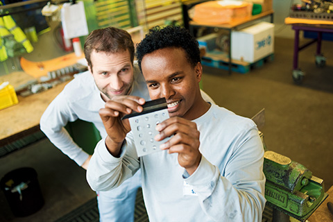 Young male employees looking at detail