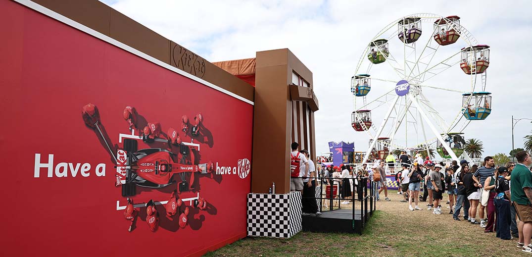 KitKat promotional booth at an outdoor event with a Ferris wheel in the background