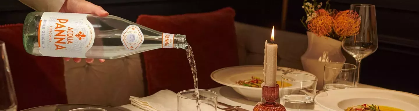 Acqua Panna natural spring water served with a fine dining meal in an elegant restaurant