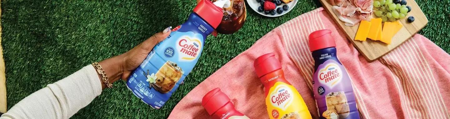 four coffee mate bottle and picnic tray on the ground