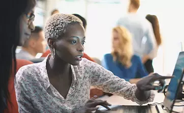 Two women looking at laptop screen and pointing at it
