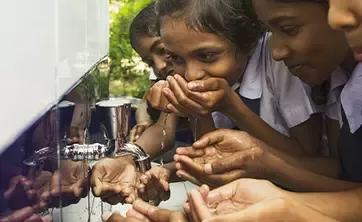 children drinking from a water tap