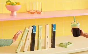 Colorful Nespresso coffee sleeves with iced drink in a bright summer kitchen setting