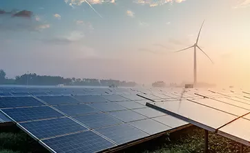 Solar panels with wind turbine in background