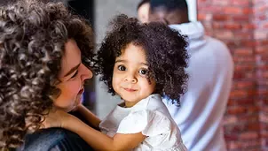 Mother holding her little daughter on hands