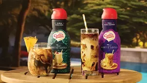 two bottles of Coffee mate with two glasses of iced coffee on table