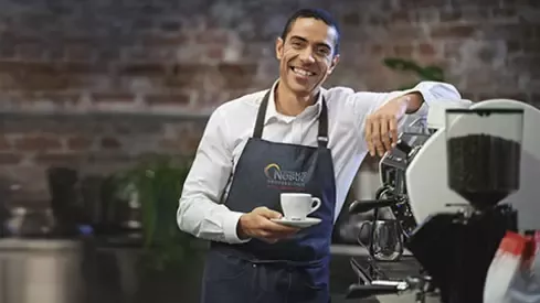 Barista holding cup of coffee