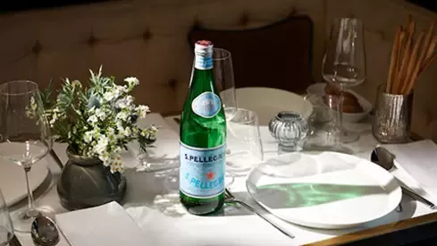 S.Pellegrino sparkling mineral water bottle on an elegantly set restaurant table
