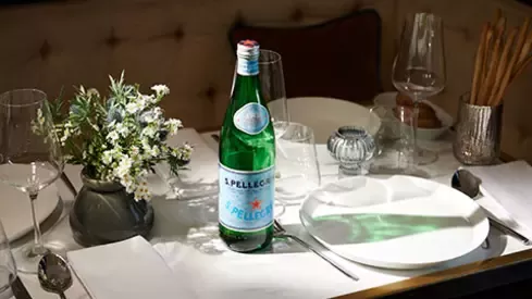 S.Pellegrino sparkling water bottle on an elegant restaurant table setting