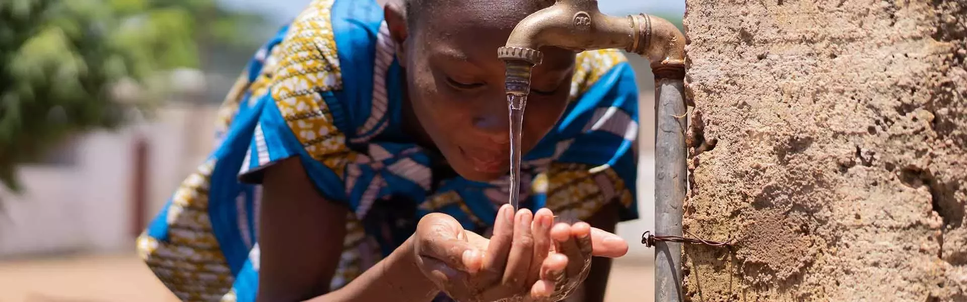 Teenager drinking out of water fountain