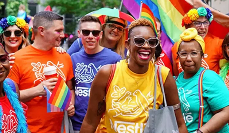 Adults smiling wearing full colors at pride week