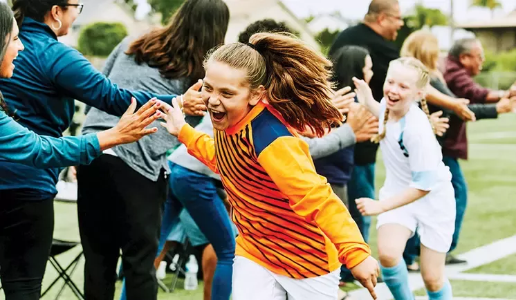 two girls giving high-fives to people