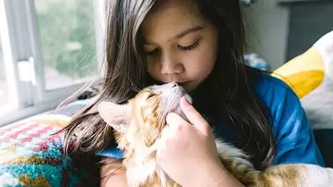 Girl hugging cat