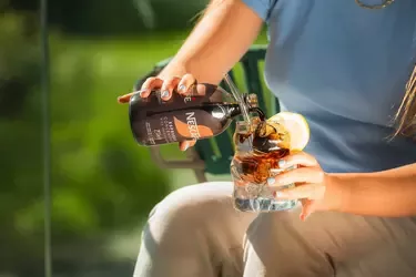 A woman is pouring coffee into a cup