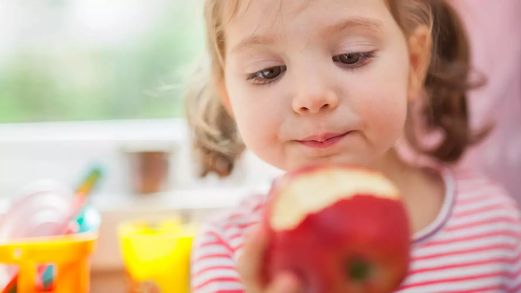 Little girl eating apple