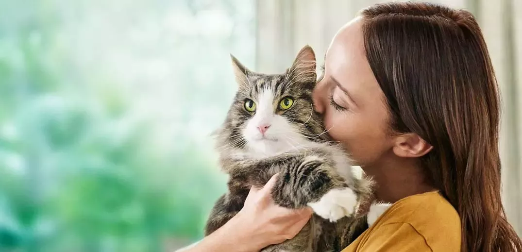woman hugging cat