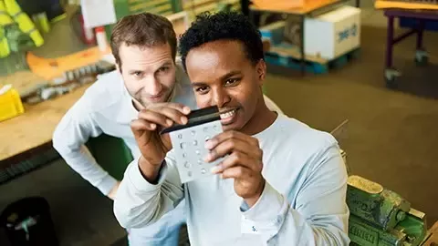Young male employees looking at detail