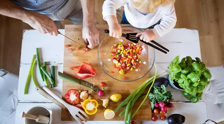 Father and child cutting vegetables