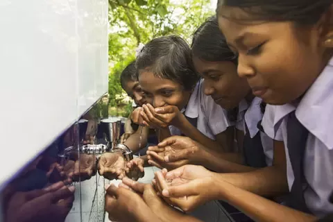 Children drinking out of water fountain