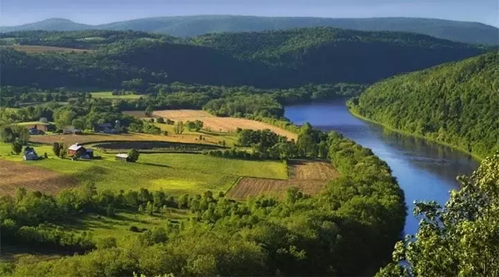 a green landscape with a river running through it