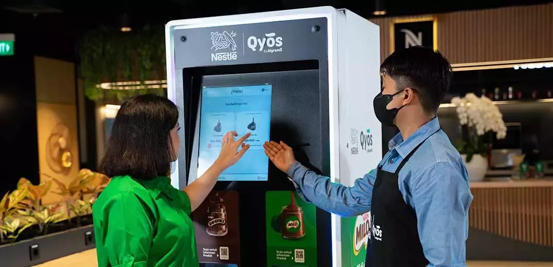 Man and woman using Milo vending machine
