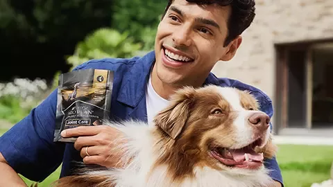 Man cuddling dog