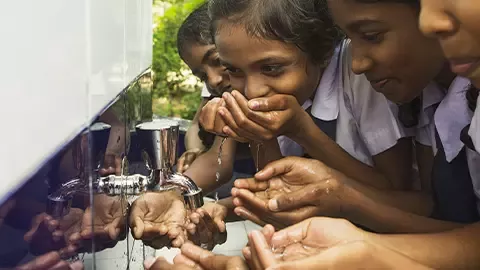 Children drinking from a tap