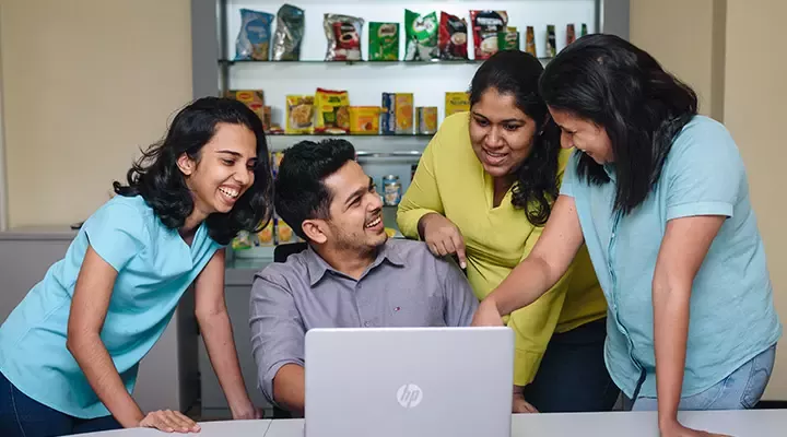 People gathered around a laptop