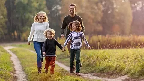 family walking in the park with two little kids