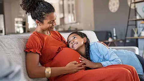 Pregnant woman with her little daughter