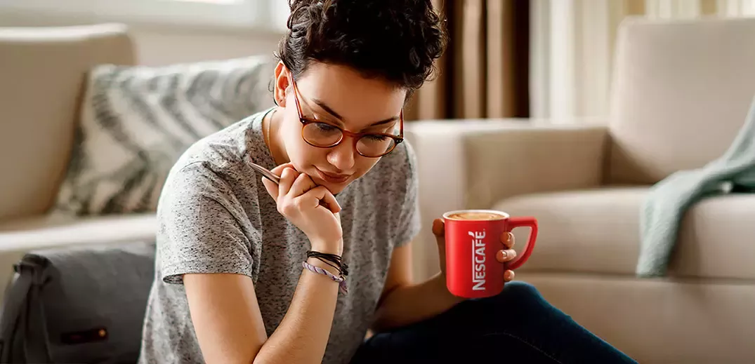 Lady sat with Nescafé coffee