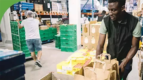 two men sort food for distribution
