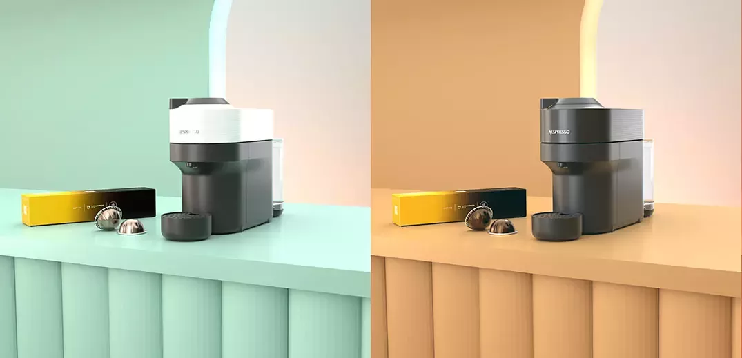 Two coffee machines side by side on colorful surfaces, one mint green and one warm orange, with coffee capsules nearby.