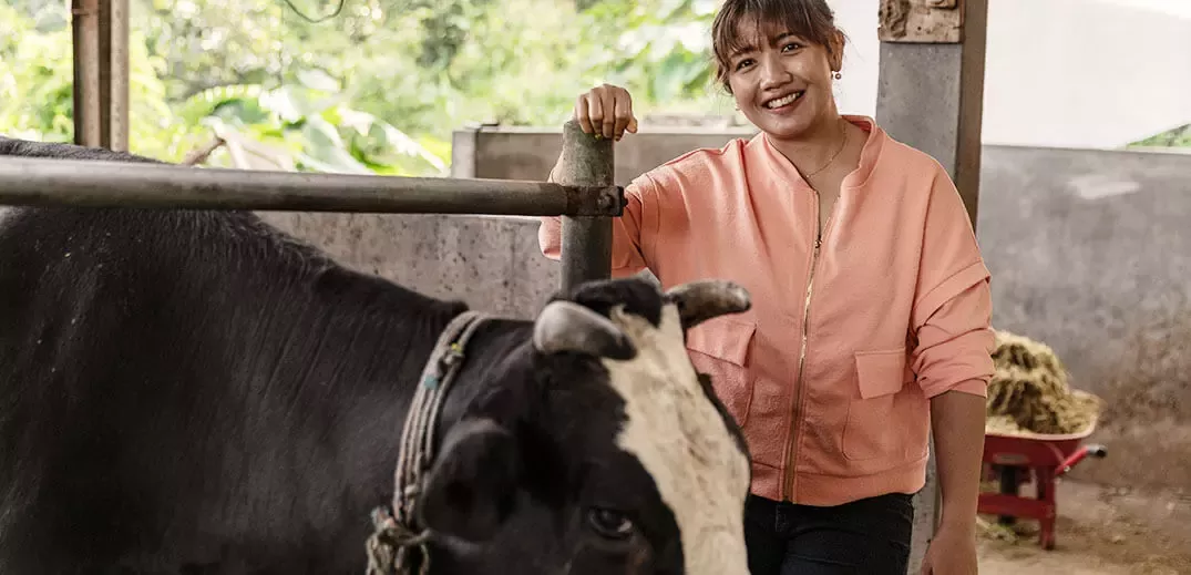 a farmer woman standing next to cow