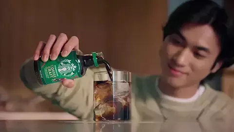 pours starbucks coffee in a cup 