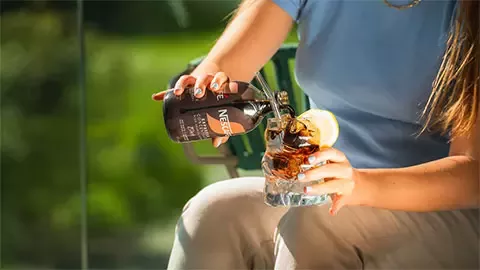 A woman is pouring coffee into a cup