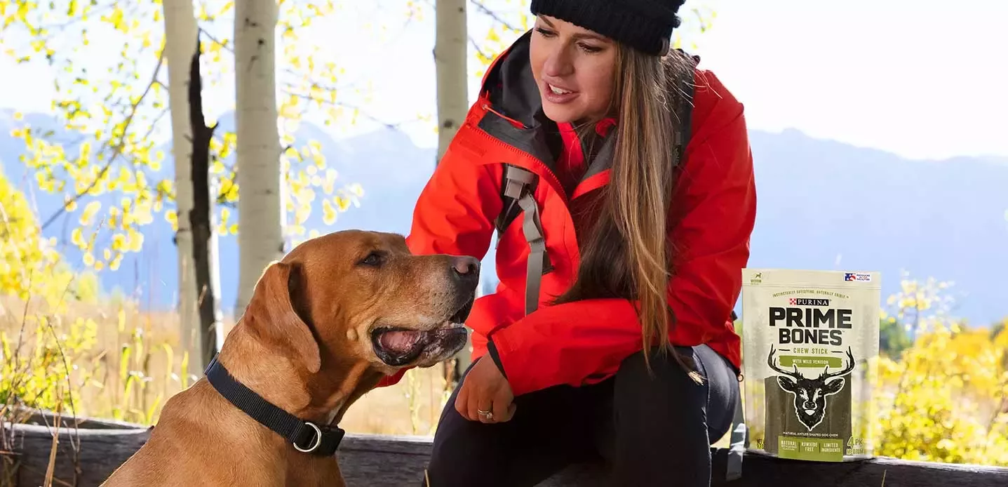 Woman giving dog Prime Bones
