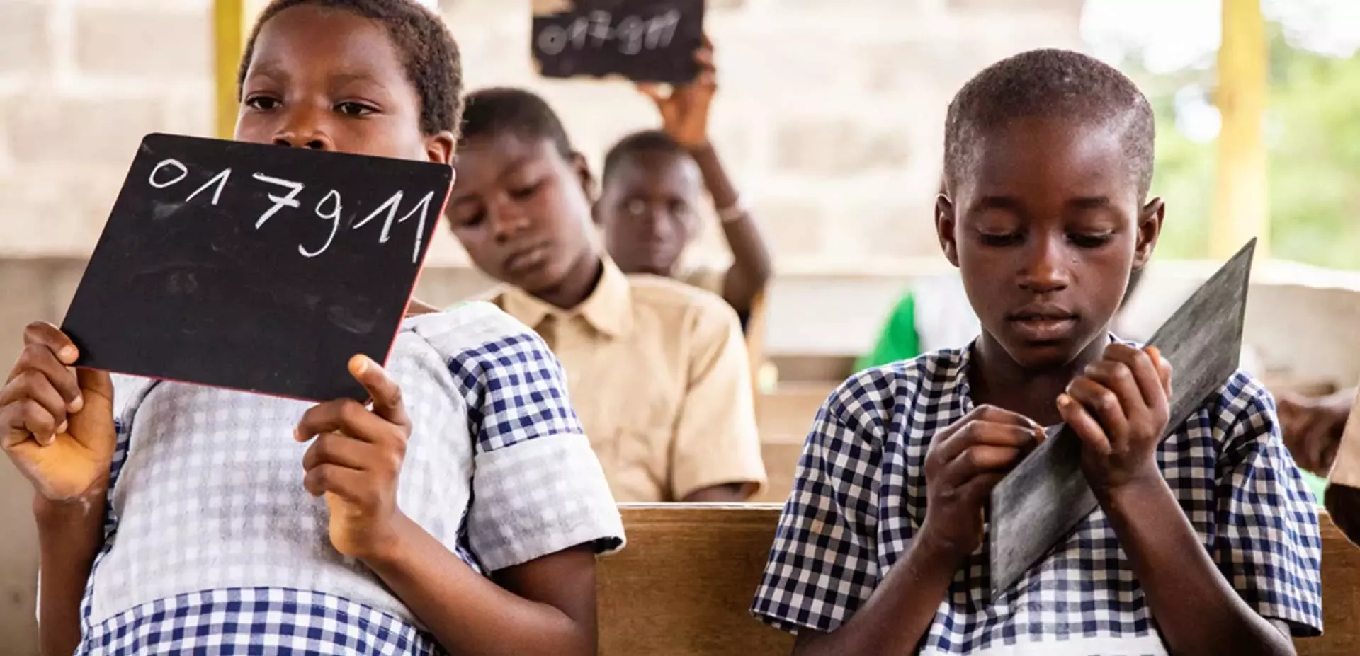 African schoolchildren writing on chalk boards